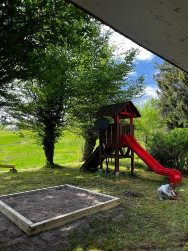 a playground with a red slide and a play structure at Hotel zum Kreuz in Sankt Peter