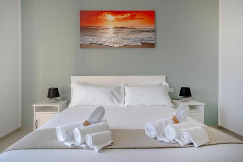 a bedroom with a white bed with two night stands at Pausa Mare Outside in Torre a Mare