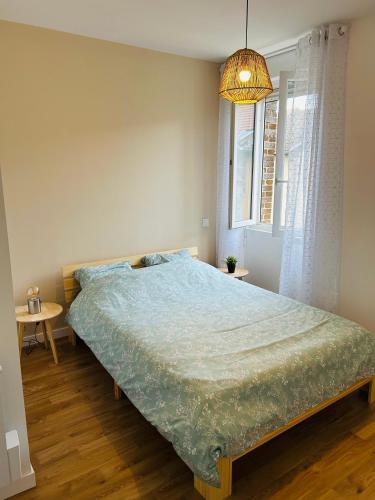 une chambre avec un lit avec une couette bleue et une fenêtre dans l'établissement Au Pilat, à Pélussin