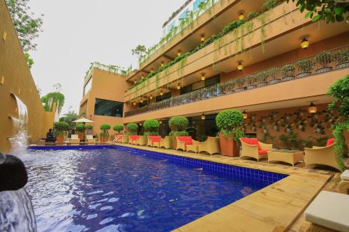a hotel with a swimming pool in front of a building at Sayaji Rajkot in Rajkot