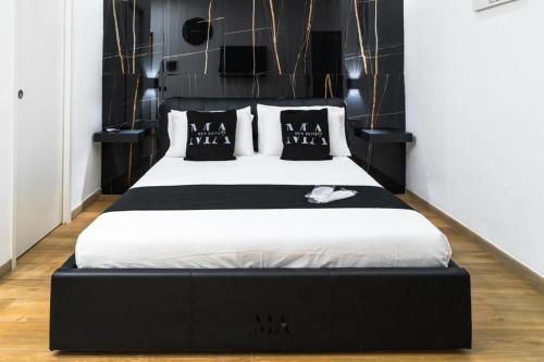 a bedroom with a bed with a black headboard at MEA Suite in Palermo