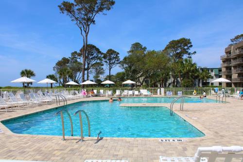 a large swimming pool with chairs and umbrellas at Ocean One 222 in Hilton Head Island