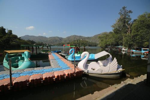 a group of boats parked in the water at ROYAL ROSETTE LAKE VIEW Bhimtal in Nainital