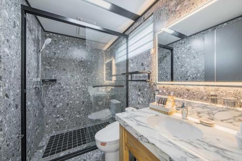 a bathroom with a shower and a sink and a toilet at Anji Pu An Tea House Hotel in Anji