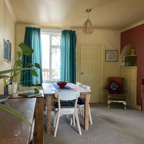 a dining room with a table and blue curtains at Terraced Garden House Three Bedrooms in Stamford