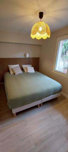 une chambre avec un grand lit et un lustre dans l'établissement Cozy apartment for 4 people, beach 100m away, à Fréjus