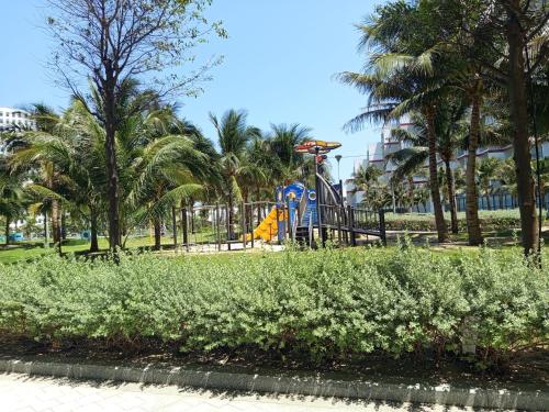 a playground in a park with palm trees at Sarang Arena Cam Ranh Seaview Resort condotel in Cam Ranh International Airport