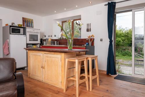 La cuisine est équipée d'un comptoir avec évier et d'un réfrigérateur. dans l'établissement Longère de charme, à Kervignac