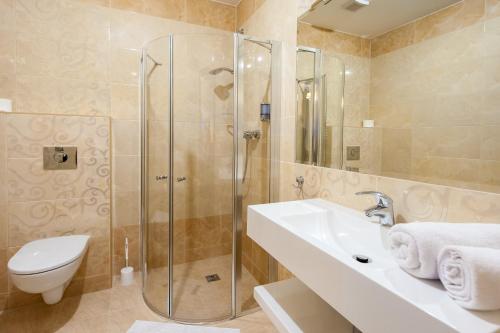 een badkamer met een douche, een toilet en een wastafel bij Hotel Buczyński****Medical&SPA in Świeradów-Zdrój