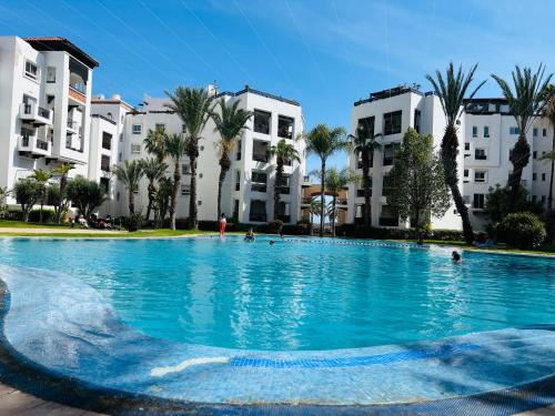 a large swimming pool in front of buildings at Marina Agadir appartement standing 90m2 + piscine in Agadir