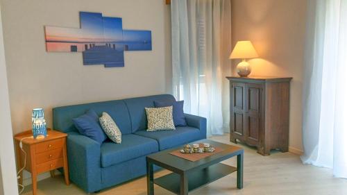 un soggiorno con un divano blu e un tavolo di Casa Domenica a Baveno