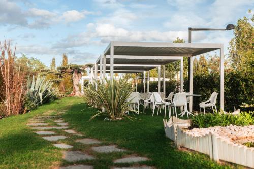 a table and chairs under a pavilion in a garden at Relais Bellaria Hotel & Congressi in Bologna