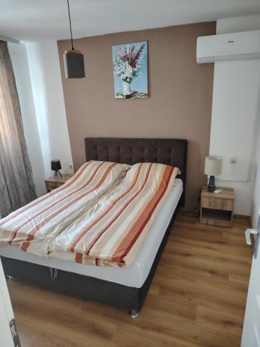 a bedroom with a bed with a striped blanket on it at Vila Oaza mira in Vražići
