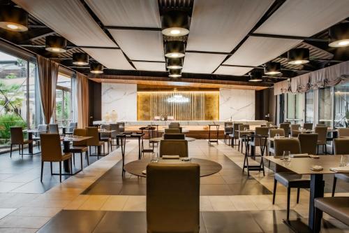 a dining room with tables and chairs and windows at Relais Bellaria Hotel & Congressi in Bologna