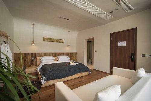 a bedroom with a bed and a couch at Anji Pu An Tea House Hotel in Anji