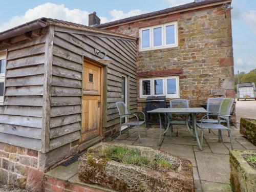 a house with a patio with a table and chairs at Sprinks Farm in Leek