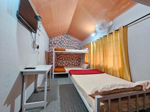a small room with two beds and a desk at Bamboo leaf Homestay in Meppādi