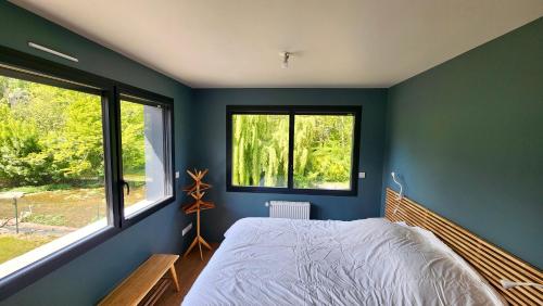 ヴール・レ・ローズにあるConfort détente près de la plageの青い壁と窓のあるベッドルーム(ベッド1台付)