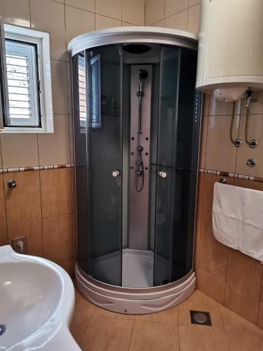 a shower with a glass door in a bathroom at Apartmani BISERKA in Šibuljina