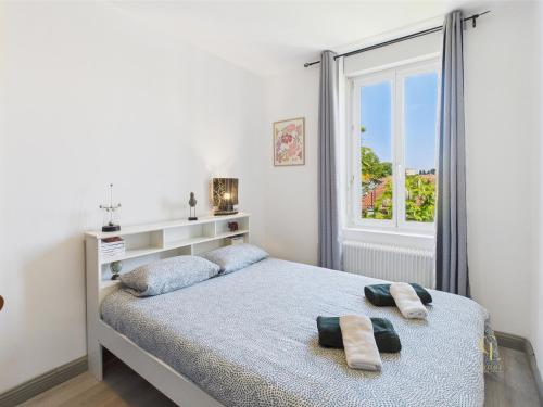une chambre avec un lit avec deux serviettes dessus dans l'établissement Cocon Blanca- 1er étage prox centre Mulhouse, à Mulhouse