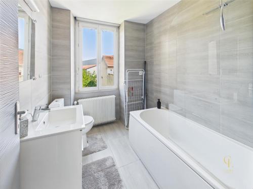 une salle de bain blanche avec une baignoire et un lavabo dans l'établissement Cocon Blanca- 1er étage prox centre Mulhouse, à Mulhouse