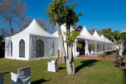 a white tent with a tree in the grass at Elba Motril Beach & Business Hotel in Motril