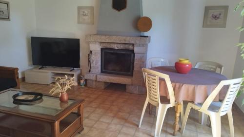 a living room with a table and a fireplace at Gîte Lann Er Viline in Camors