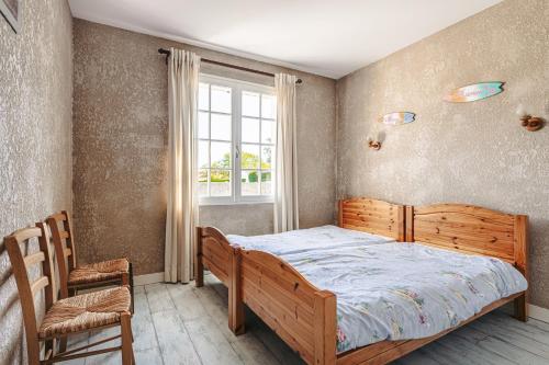 une chambre avec un lit en bois et une fenêtre dans l'établissement Maison au Coeur de Grand Village, à Grand-Village-Plage