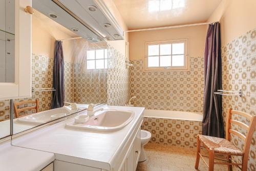 une salle de bain avec un lavabo, une baignoire et des toilettes dans l'établissement Maison au Coeur de Grand Village, à Grand-Village-Plage