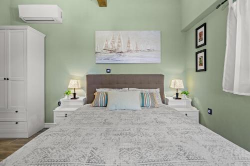 Un dormitorio con una cama grande con dos mesitas de noche. en Krasna kuća, en Labin