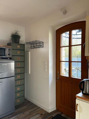 une cuisine avec un réfrigérateur blanc et une porte dans l'établissement Charmante Maison avec Parc entre Seine et Forêt de Fontainebleau à 30mn de Paris, à Bois-le-Roi