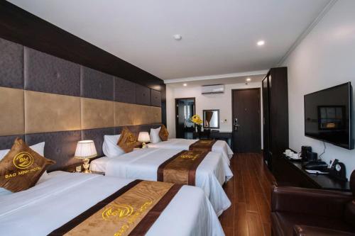 a hotel room with two beds and a flat screen tv at BẢO MINH RADIANT in Ha Long