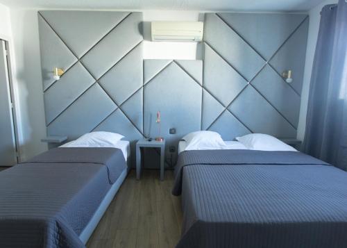 two beds in a room with blue walls at Casa Marana by Le Lido in Lucciana