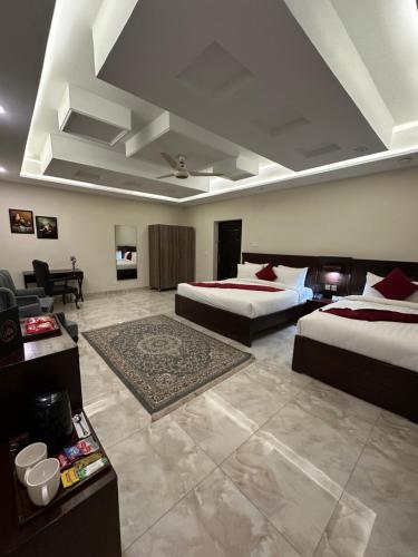 a large room with two beds and a couch at Burj Ul Zaki in Islamabad
