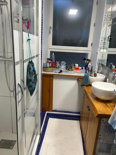 - une petite cuisine avec un évier et un miroir dans l'établissement La grange à Tabac, à Goujounac