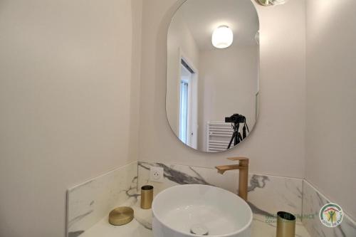 une salle de bain blanche avec un lavabo et un miroir dans l'établissement Ker touro, à Trégastel