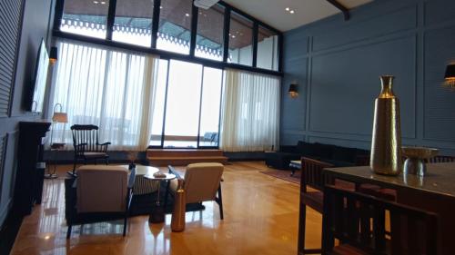 a living room with a table and chairs and a large window at Polo Cherrapunjee Resort in Cherrapunji