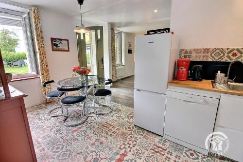 une cuisine avec une table et un réfrigérateur blanc dans l'établissement Enez roch, à Paimpol