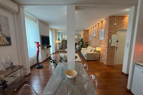 un salon avec une table en verre et un mur en briques dans l'établissement REF 1988 -Charming apartment in the center of Cannes, à Cannes
