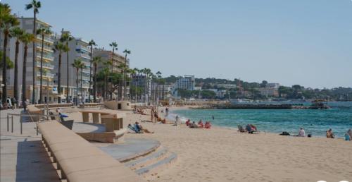 une plage avec des personnes assises sur le sable et l'eau dans l'établissement Apartment sea side, à Antibes