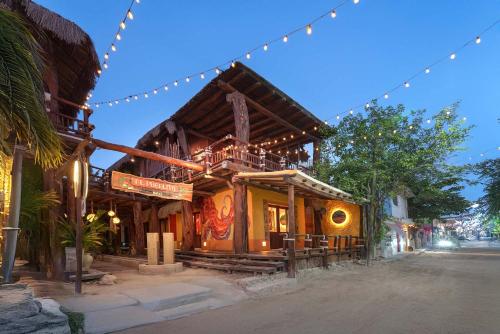 a large wooden building with lights on it at Exe El Pueblito in Holbox Island