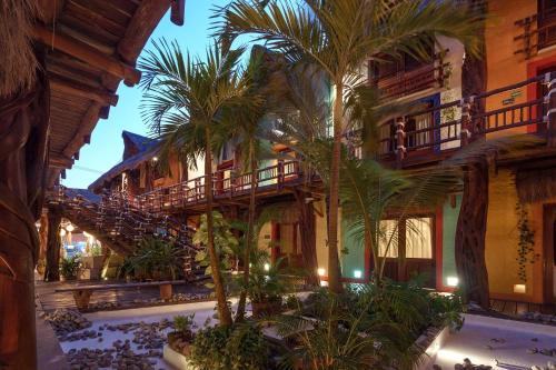 a building with palm trees in front of it at Exe El Pueblito in Holbox Island