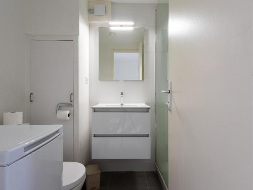 トレブールダンにあるDuplex Vue Mer by Madame est Servieの洗面台とトイレを備えた白いバスルーム