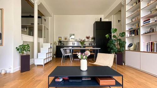 un salon avec une table et une cuisine dans l'établissement Quiet and bright loft, à Paris