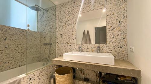 une salle de bain avec un lavabo, un miroir et une baignoire dans l'établissement Quiet and bright loft, à Paris