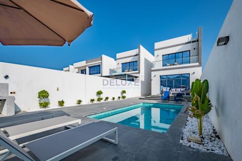 an image of a villa with a swimming pool at Blue Marble Beach 4BR Villa with Assistants Room, Private Pool, Access to Floating Pier, and Sea and Mountain Views, Al Dana Island, Fujairah by Deluxe Holiday Homes in Fujairah