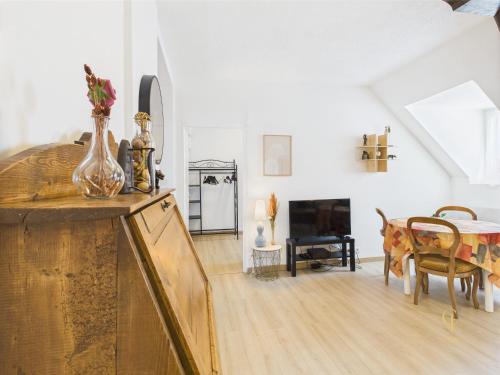 - un salon avec un vase de fleurs sur un comptoir dans l'établissement Cocon Jaune - Duplex 2e étage prox centre Mulhouse, à Mulhouse