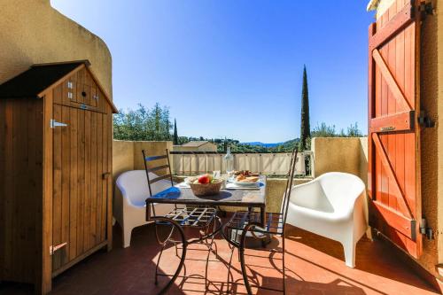 un patio avec une table et des chaises sur un balcon dans l'établissement SELECT'so HOME - Superbe T2 avec vue mer pour un séjour relaxant - Piscine et Parking inclus - PARADISIA, au Lavandou