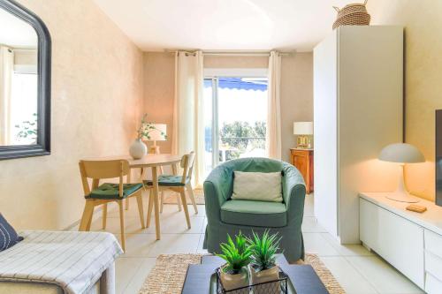 un salon avec une chaise verte et une table dans l'établissement SELECT'soHOME - Studio pour 2 personnes à deux pas du centre-ville du Lavandou avec parking privé - TERRAZZA, au Lavandou