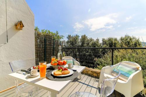 une table avec une assiette de nourriture sur un balcon dans l'établissement SELECT'soHOME - Studio pour 2 personnes à deux pas du centre-ville du Lavandou avec parking privé - TERRAZZA, au Lavandou